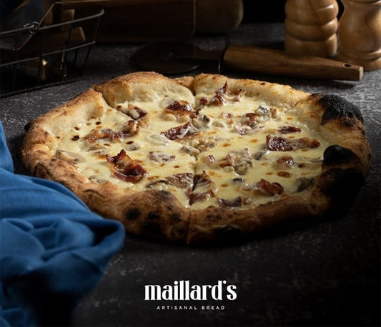 Pizza with cheese and bacon on a dark surface, featuring the Maillard's logo.