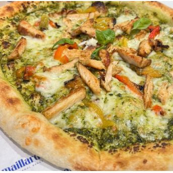 Pizza with chicken, vegetables, and pesto on a white background